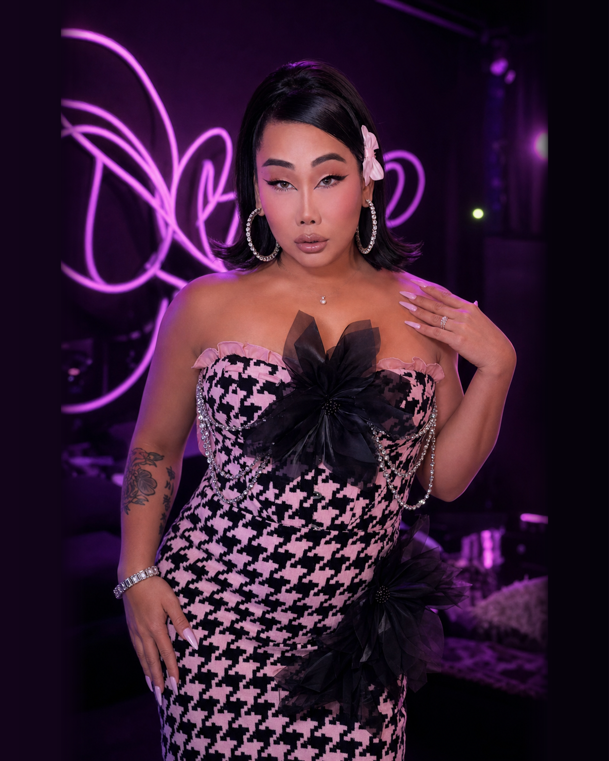 Gia Gunn in a houndstooth couture look inside a purple neon LIVE studio